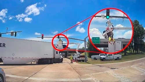 Camión golpea a trabajador que arreglaba semáforo y lo deja colgando del arnés